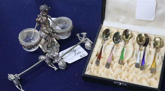 A cased set of six silver gilt and coloured enamel coffee spoons, a pair plated Greyhound knife rests